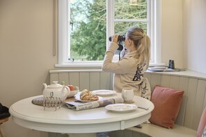 A person using a camera at a table with a teapot, croissants, and a newspaper. - Ware Lodge at Woodhall Park | Sleeps 3 (Hetford)