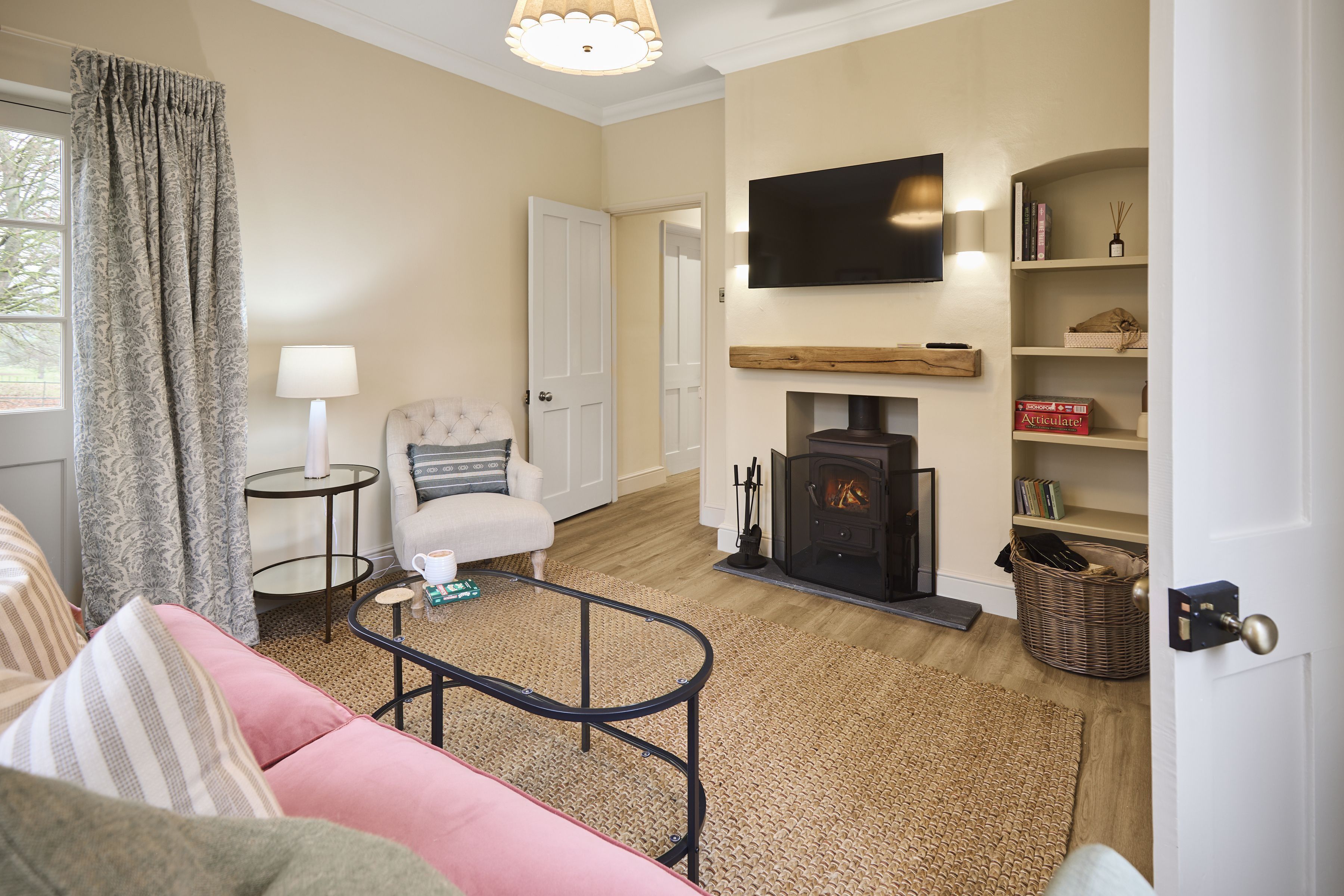 A cozy living room with a sofa, a television, a fireplace, and a bookshelf.