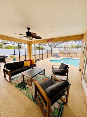 A covered patio with a ceiling fan, a pool, and a view of a fenced backyard. - Family-Friendly Bradenton Retreat with Private Pool (Bradenton)