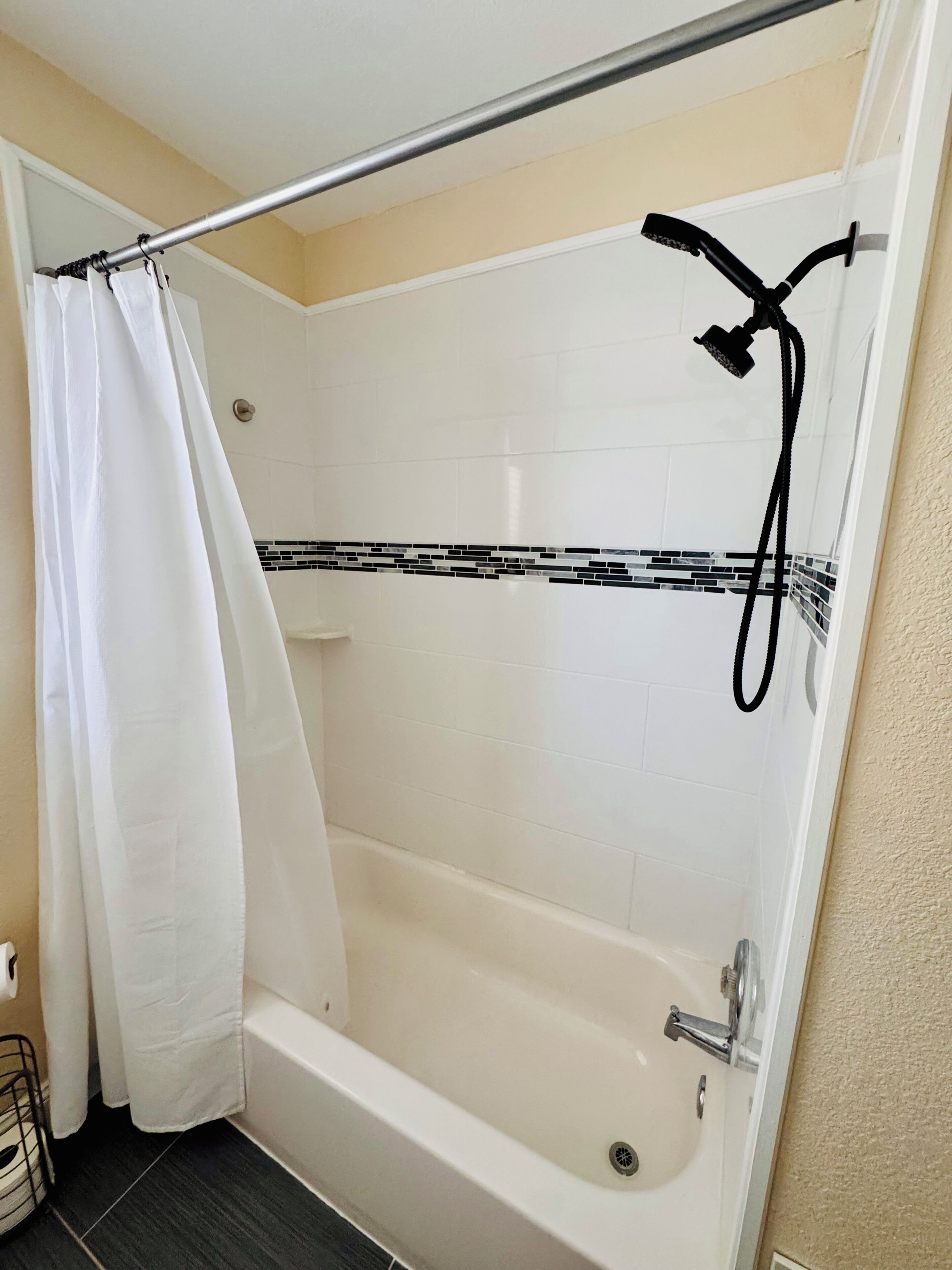 A bathroom with a bathtub, shower, and a curtain.