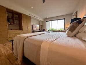 A modern bedroom with a large bed, built-in wardrobe, and a large window providing a view. - Luxury Studio at Valarte with Resort Amenities in Prime Puerto Vallarta Location (Puerto Vallarta)