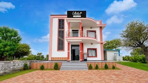 A multi-story building with a balcony, a sign indicating it is serviced by OYO, and a paved entrance area. - Collection O Salasar Balaji Temple (Sujangarh)