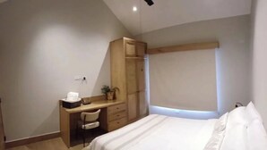 A bedroom with a bed, a desk, a chair, a wardrobe, and a ceiling fan. - Boquete Cabins Retreat (Bajo Boquete)
