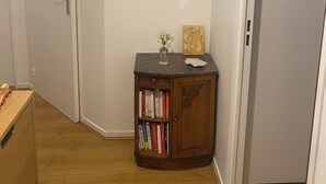 Un pasillo con un aparador de madera, un reloj en la pared y una puerta.