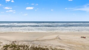 Une plage avec un ciel dégagé et des vagues sur l’océan.