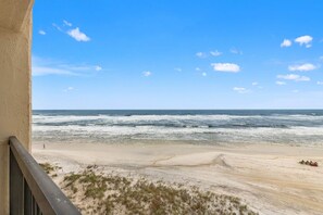 A beach view from a balcony with a sandy foreground and ocean waves. - Pinnacle Port, C3-501 (Panama City Beach)