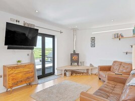 Una sala de estar moderna con televisor, chimenea, sofá y mueble de madera.
