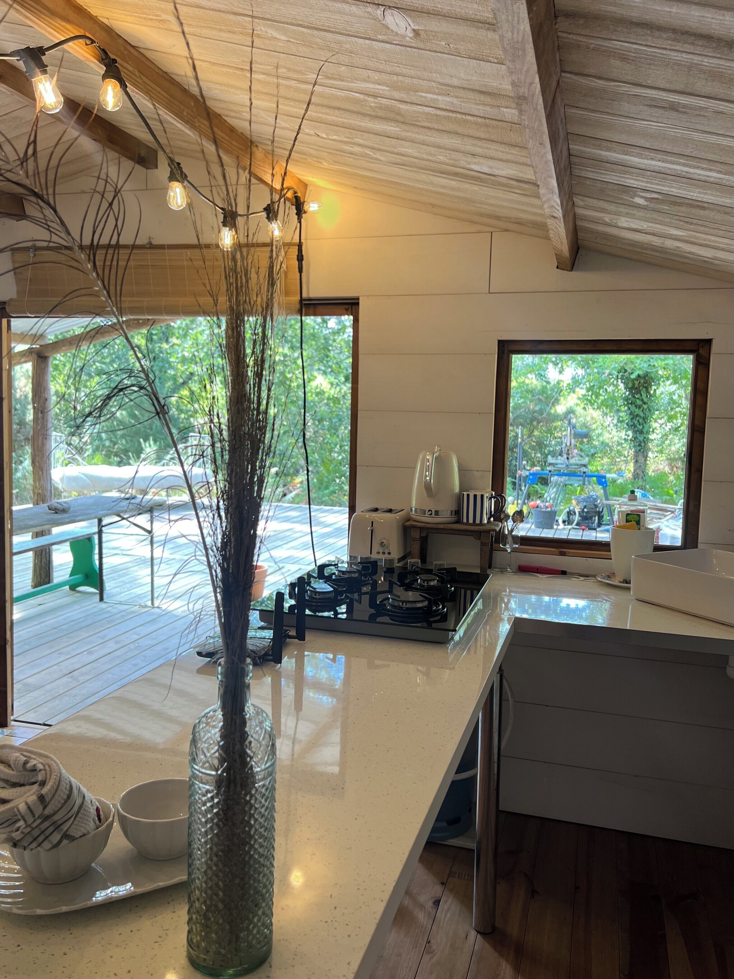 Una cocina moderna con una isla central, estufa y ventana con vista a una terraza.