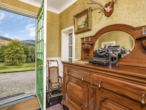 A room with a wooden dresser, a mirror, a typewriter, and a framed picture on the wall. - Pretty Estate House With Hot Tub (Colintraive)