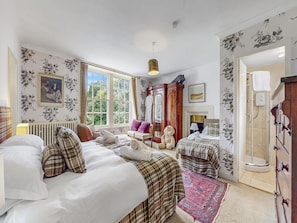 A bedroom with a large bed, a smaller bed, a wardrobe, a mirror, and a window with a view of greenery. - Pretty Estate House With Hot Tub (Colintraive)