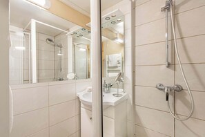 A modern bathroom with a glass shower enclosure, a sink, and a mirror. - Residence Arcelle, Ski In-Out with WiFi in Val Thorens, “V1” by Versant Collection (Val Thorens)