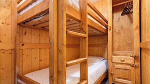 A wooden bunk bed room with a wooden wardrobe and a small shelf. - Residence Arcelle, Ski In-Out with WiFi in Val Thorens, “V1” by Versant Collection (Val Thorens)