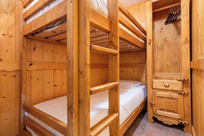 A wooden bunk bed room with a wooden wardrobe and a small shelf. - Residence Arcelle, Ski In-Out with WiFi in Val Thorens, “V1” by Versant Collection (Val Thorens)