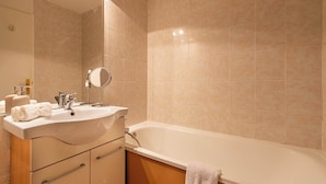 Ein Badezimmer mit Waschbecken, Spiegel und Badewanne.