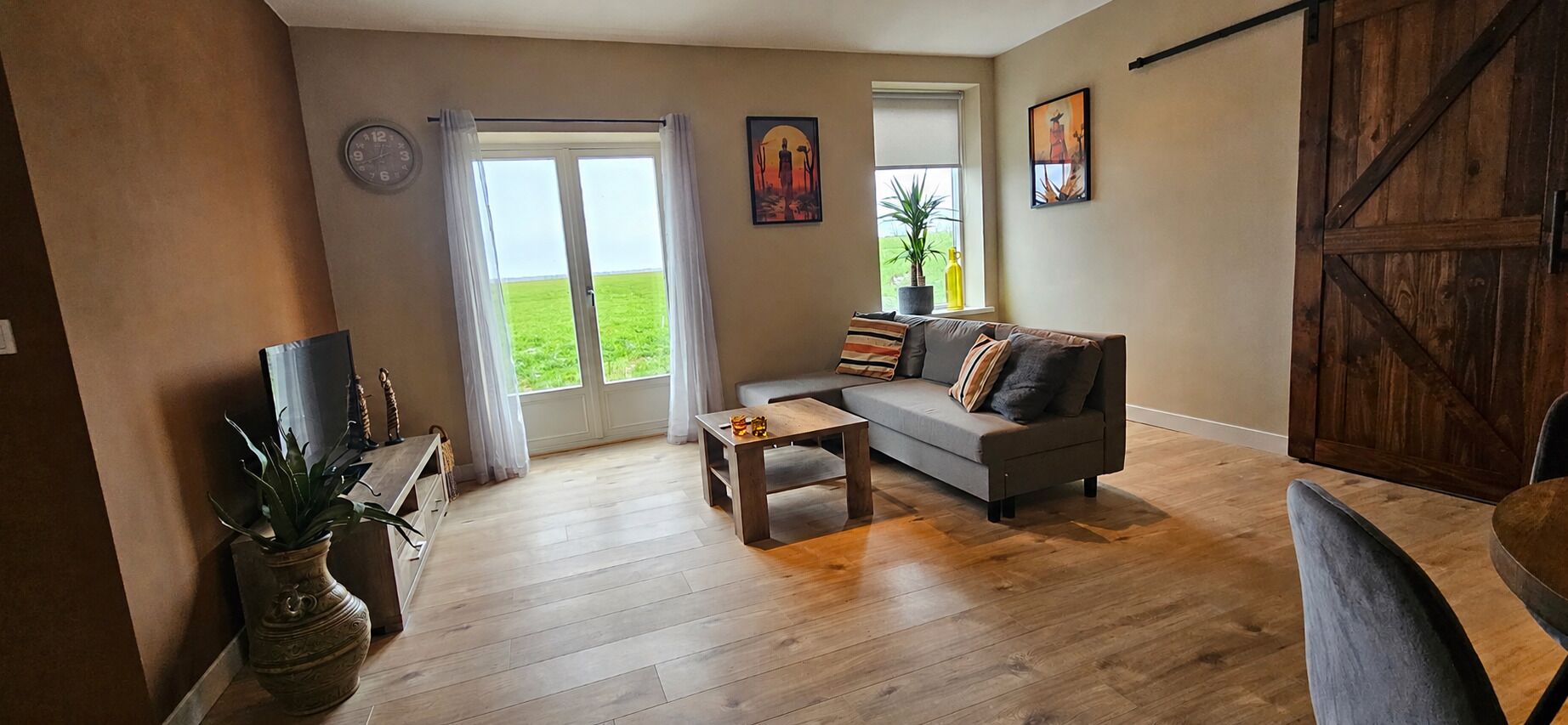 A living room with a sofa, coffee table, and a large window with curtains.