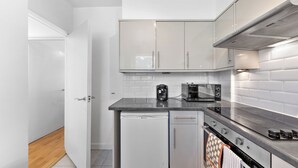 Une cuisine de taille réduite équipée d’un lave-vaisselle, d’un grille-pain et d’une cuisinière.