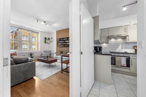 Un appartamento moderno con soggiorno, cucina e zona pranzo.