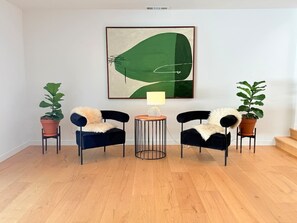 A room with two black chairs, a small wooden table, and two potted plants. - Lavender House + Guest Suite - Sleeps 11 (Ojai)