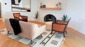 Una sala de estar moderna con un sofá, un sillón y una chimenea.