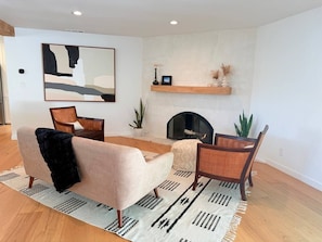 A modern living room with a sofa, armchair, and a fireplace. - Lavender House + Guest Suite - Sleeps 11 (Ojai)