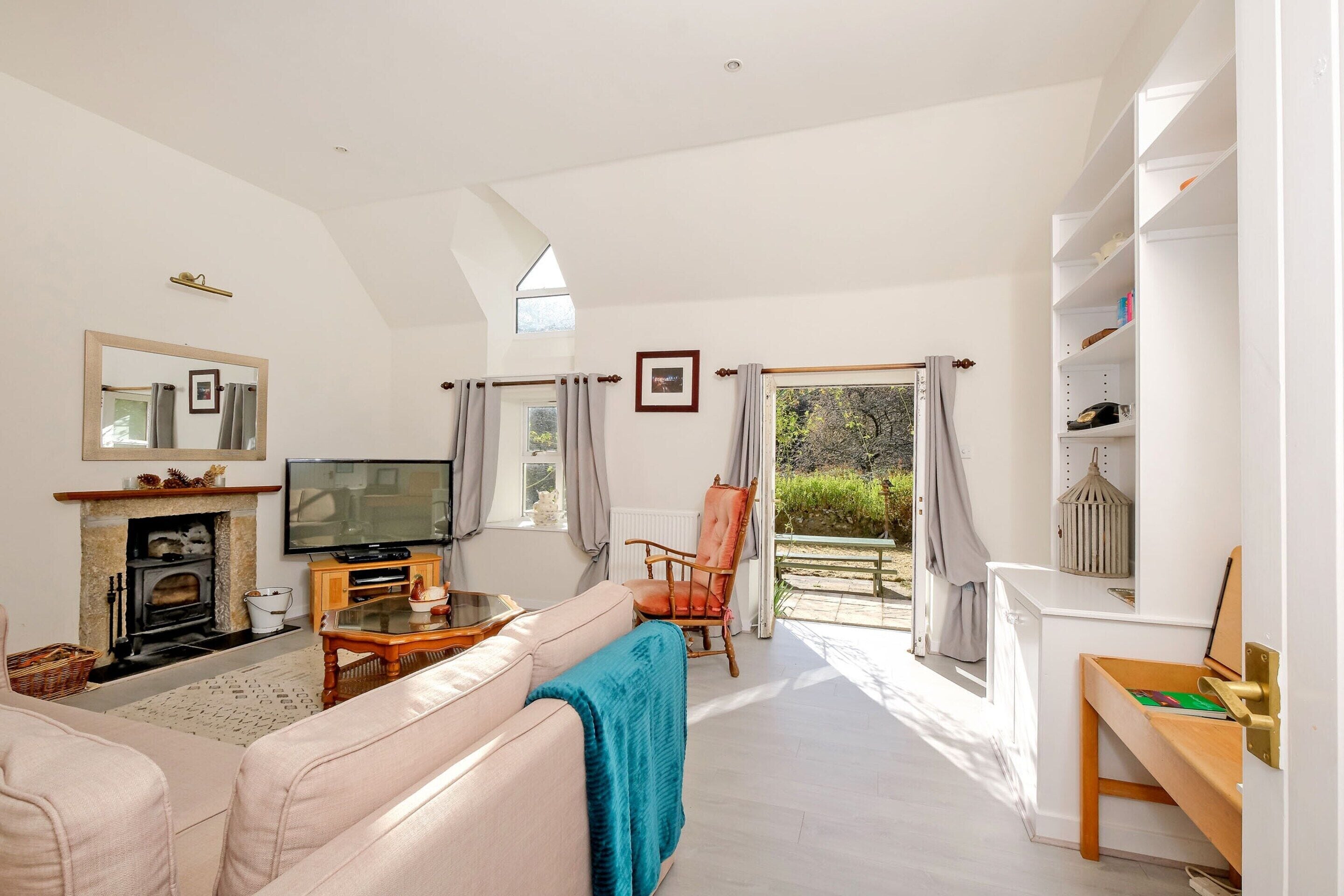 A spacious living room with a fireplace, television, and comfortable seating.