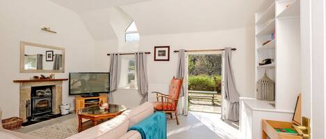 A spacious living room with a fireplace, television, and comfortable seating.