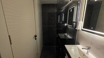 Un bagno moderno con un lavandino bianco, uno specchio e un water.