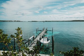 A clear view of a dock extending into a calm body of water with a boat moored at the end.