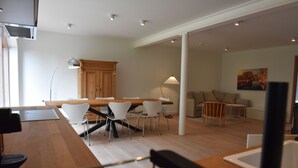 Ein modernes Interieur mit Essbereich, Küche und Sitzgelegenheiten.