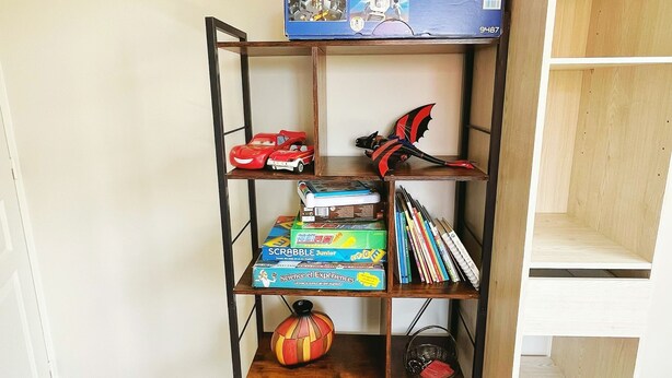 A bookshelf with a playmobil set, books, and a decorative pumpkin.