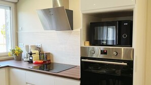 A modern kitchen with a stainless steel range hood, a built-in microwave, and a black oven.