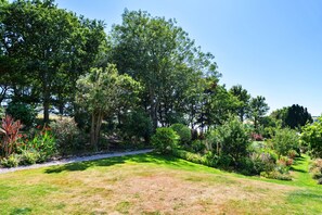 A well-maintained garden with a variety of trees and shrubs, a clear pathway, and a grassy area. - House With Private Vineyard (Looe)