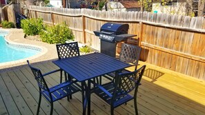 A deck with a grill, pool, and seating area. - Spacious 3bedroom house in the heart of San Antonio with Pool/hottub and Game Rm (San Antonio)