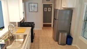 A kitchen with a stainless steel sink, a stove, and a refrigerator. - Spacious 3bedroom house in the heart of San Antonio with Pool/hottub and Game Rm (San Antonio)