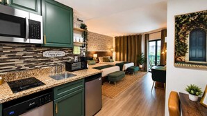 Eine moderne Küche mit Geschirrspüler, Mikrowelle und Kaffeemaschine. Ein Essbereich mit Tisch und Stühlen ist ebenfalls vorhanden.