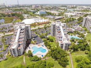 Un edificio residencial alto con piscina y zonas ajardinadas.