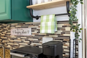 A kitchen with a tiled backsplash, a coffee maker, and a sign that says 'this is our happy place.' - Relax studio Pool and Lake view 5 min da Universal Free parking no fee resort (Orlando)