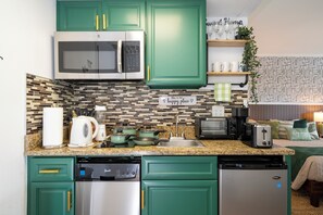A compact kitchen with green cabinets, a microwave, a toaster, and a coffee maker. - Relax studio Pool and Lake view 5 min da Universal Free parking no fee resort (Orlando)