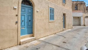 A building with a blue door and a window with shutters. - Charming 1BR Maltese Maisonette w/ Terrace, Luqa (Ħal Luqa)