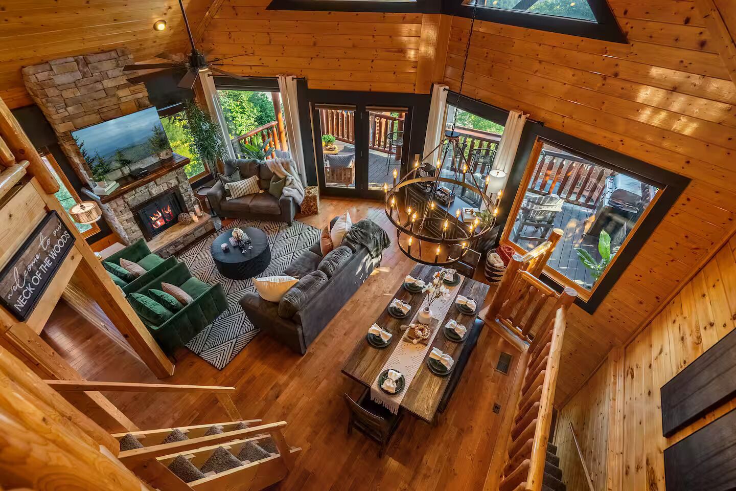 A spacious wooden cabin with a fireplace, a cozy seating area, and a dining table set for four.