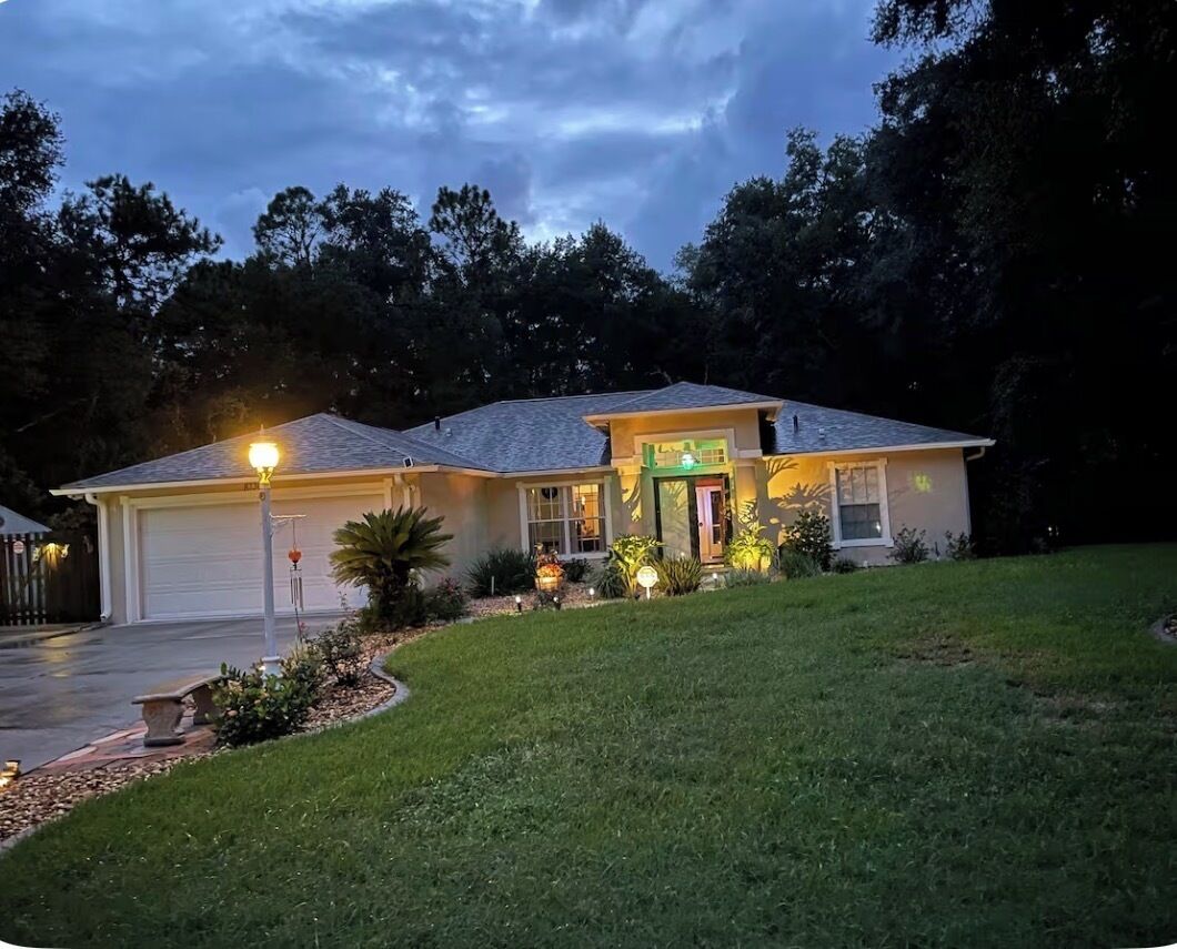 A two-story house with a garage, a front porch, and a well-maintained lawn.