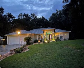 Ein zweistöckiges Haus mit Garage, Veranda und gepflegtem Rasen.