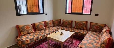 A living room with a sofa set, a coffee table, and a patterned rug.