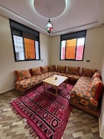 Una sala de estar con un sofá, una mesa de centro y una alfombra estampada.