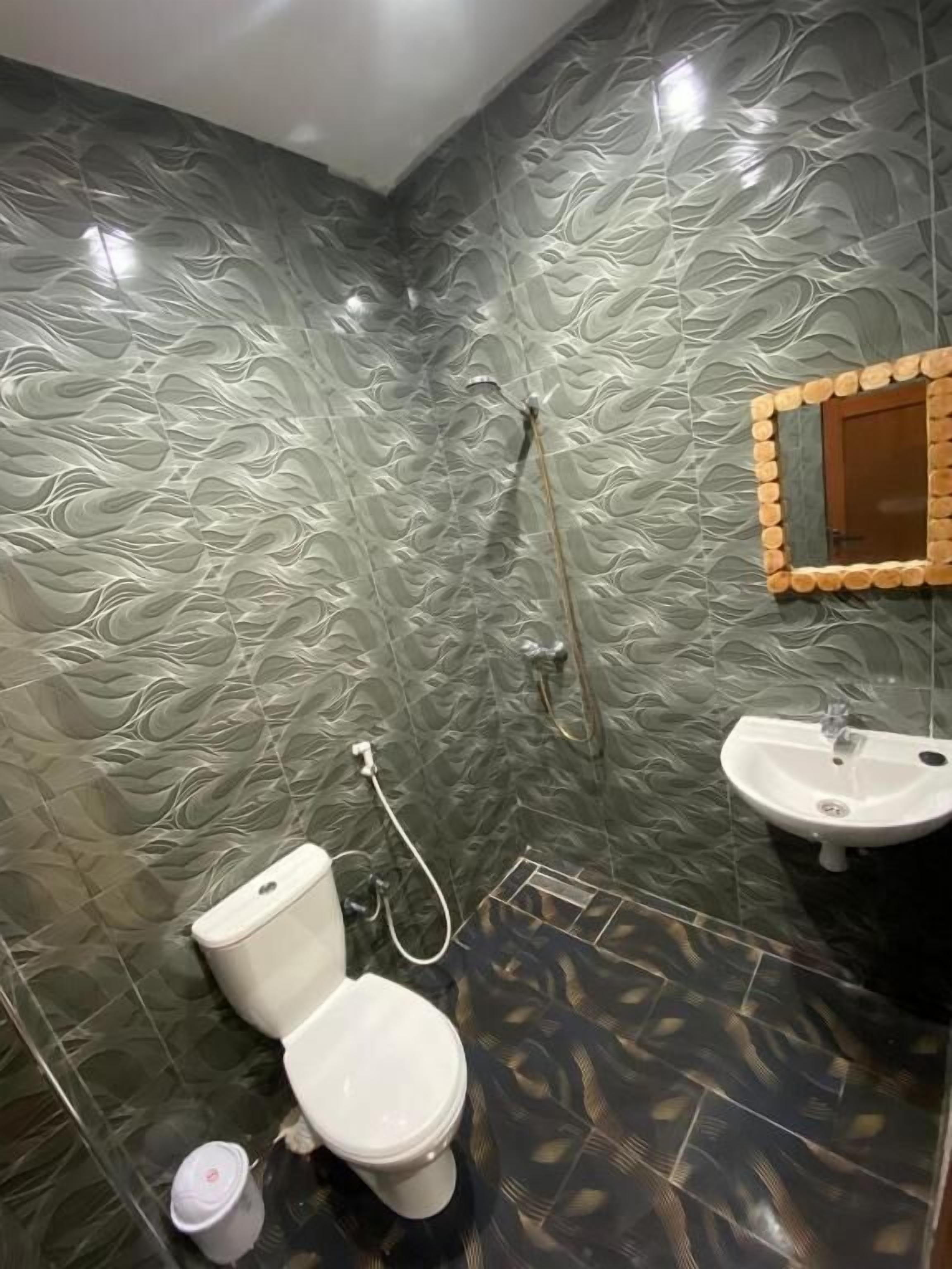 Ein Badezimmer mit Toilette, Waschbecken und Dusche.