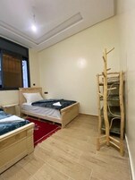 Un dormitorio con dos camas, una escalera de madera y una alfombra roja.