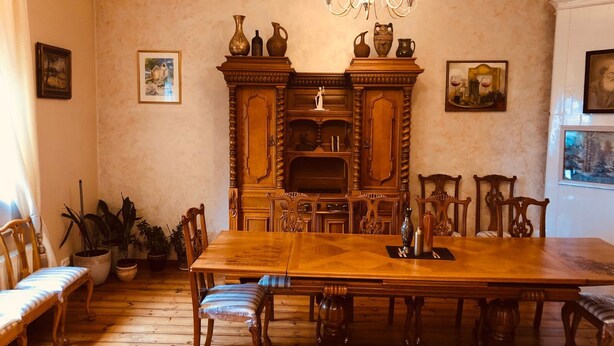 A dining room with a large wooden table, chairs, a chandelier, and a fireplace. - Classical large apartment on art deco Alberta street, FREE locked PARKING (Rīga)
