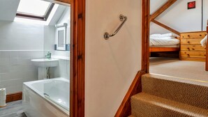 A bathroom with a bathtub, a sink, and a mirror. - Retreat Near National Parks (Torrington)