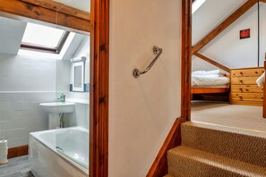 Ein Badezimmer mit einer Badewanne, einem Waschbecken und einem Spiegel.