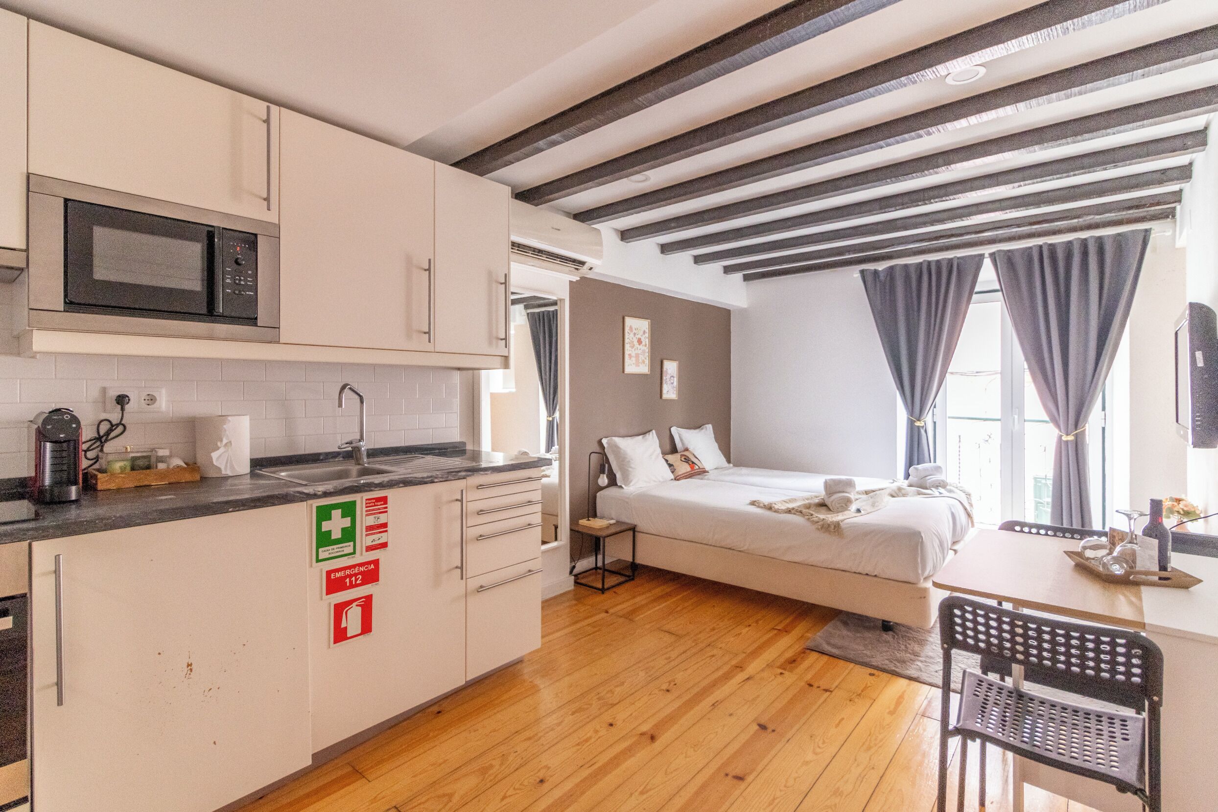 Une chambre à coucher de taille modeste, comprenant un lit, une table de chevet et une fenêtre avec des rideaux.